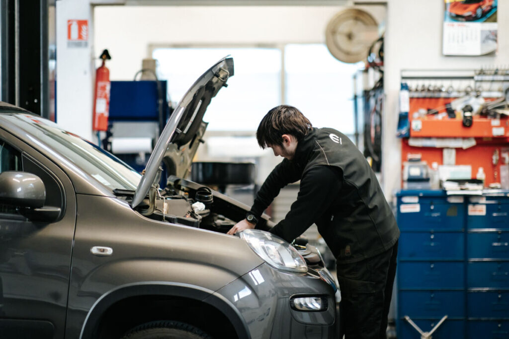 Photo d'un garagiste entrain de faire la maintenance d'une voiture
